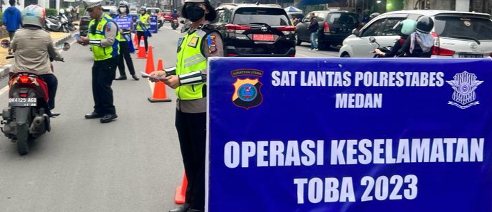 Personel Satlantas Polrestabes Medan membagi brosur tertib berlalulintas dan sticker kepada pengemudi angkutan.(ist)