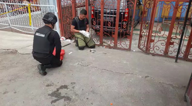 Petugas penjinak bom dari Brimob Sub Den 2 B Kota Siantar saat memeriksa benda menyerupai bom yang sempat mengeluarkan asap di Jalan Patuan Anggi, Kota Siantar, Jumat (12/5/2023).