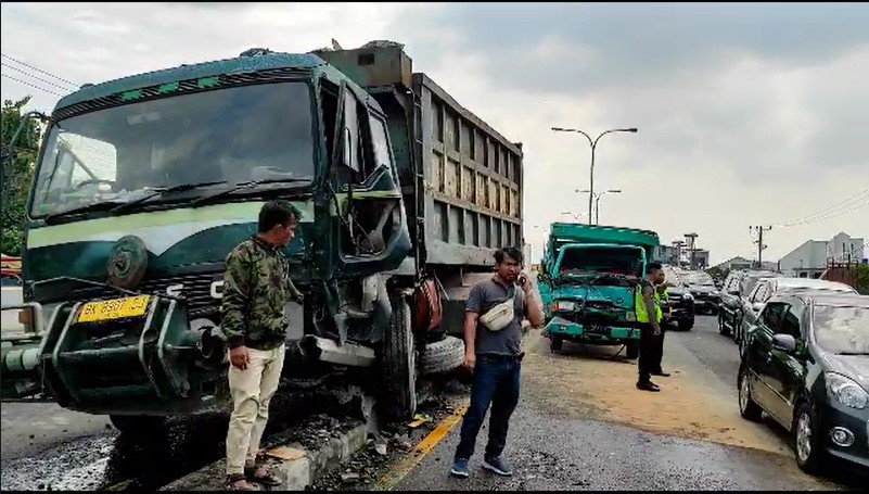 Dua truk pengangkut batu saling bertabrakan di flyover Amplas hingga menyebabkan ceceran oli berserak di jalan, Senin (3/7/2023).