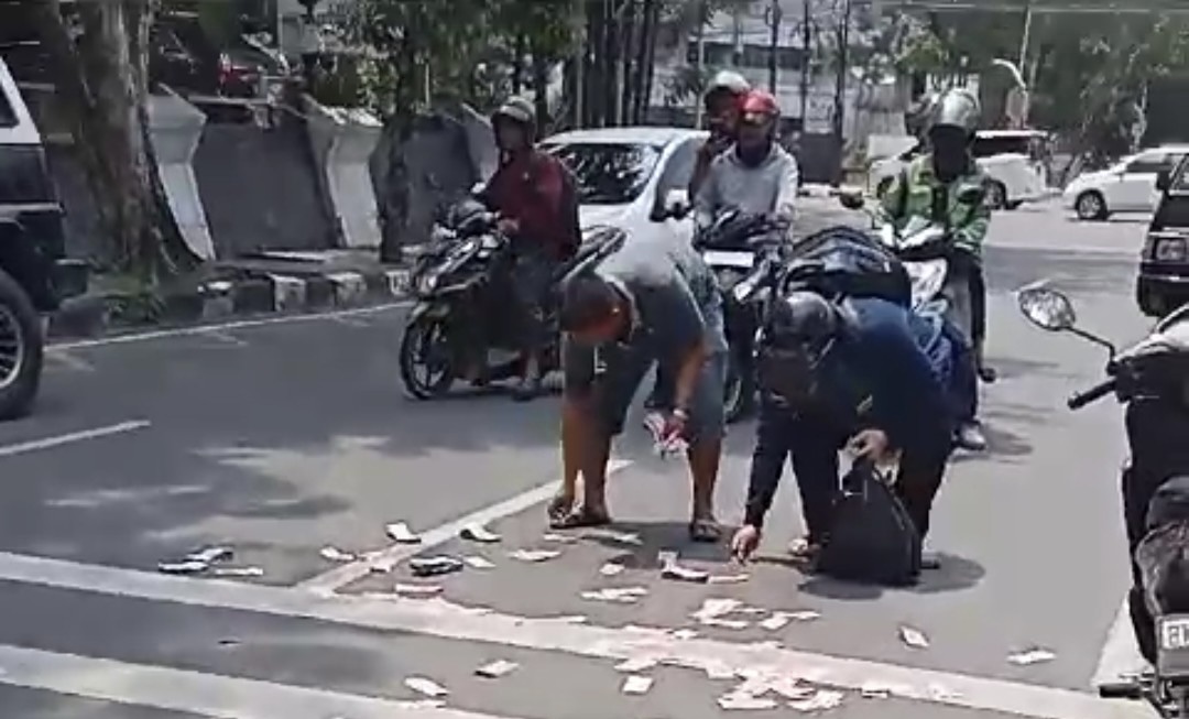 Uang pecahan Rp 100 ribu beterbangan di Jalan Imam Bonjol, Kota Medan, Senin (18/9/2023) siang.