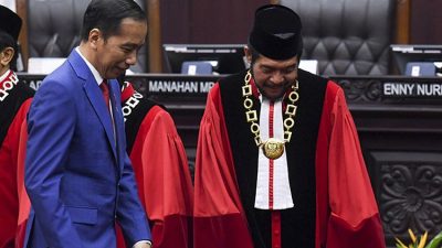 Presiden Joko Widodo (kiri) bersiap mengikuti foto bersama dengan Ketua Mahkamah Konstitusi (MK) Anwar Usman seusai sidang pleno penyampaian laporan tahun 2019 di Gedung MK, Jakarta, Selasa (28/1/2020). Sejak berdiri pada tahun 2003 hingga Desember 2019 MK telah menerima sebanyak 3.005 perkara.(ANTARA FOTO/HAFIDZ MUBARAK A)