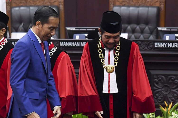 Presiden Joko Widodo (kiri) bersiap mengikuti foto bersama dengan Ketua Mahkamah Konstitusi (MK) Anwar Usman seusai sidang pleno penyampaian laporan tahun 2019 di Gedung MK, Jakarta, Selasa (28/1/2020). Sejak berdiri pada tahun 2003 hingga Desember 2019 MK telah menerima sebanyak 3.005 perkara.(ANTARA FOTO/HAFIDZ MUBARAK A)