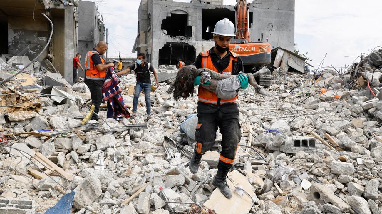 Seorang warga menolong anak yang tertimpa reruntuhan akibat serangan Israel ke Palestina