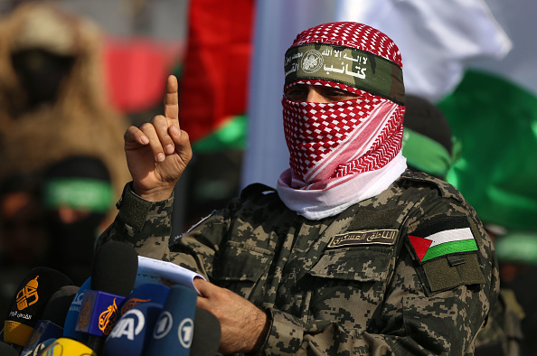 Abu Ubaida, juru bicara Brigade Izz el-Deen al-Qassam, memberi isyarat saat berbicara dalam pertunjukan militer anti-Israel di Jalur Gaza selatan, 11 November 2019. (Foto oleh Majdi Fathi/NurPhoto via Getty Images)