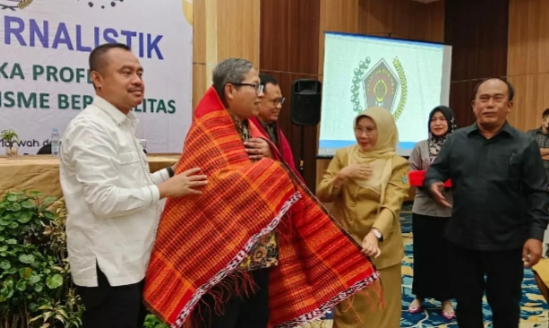 Ketua DK PWI Pusat Sasongko Tedjo pakai ulos didampingi Ketua PWI Sumut H Farianda Putra Sinik (kiri) dan Ketua DKP Sumut M Syahrir (kanan).(Ist)