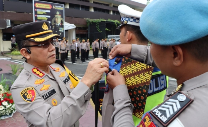 Kapolrestabes Medan Kombes Pol Teddy Jhon Sahala Marbun menyematkan pin kepada personel Ops Lilin Toba 2023.(Ist)
