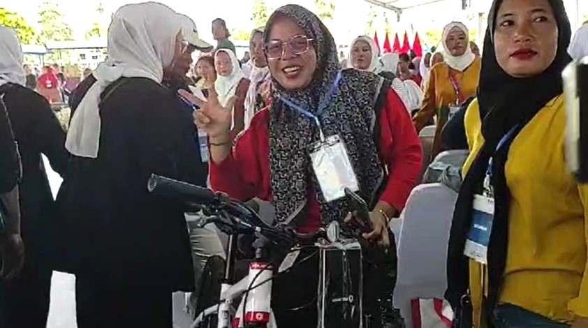 Seorang wanita bernama Habibi kegirangan setelah mendapat hadiah sepeda dari Presiden RI, Joko Widodo, Rabu (7/2/2024).