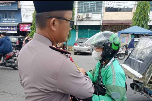 Kapolsek Sunggal Kompol Bambang G. Hutabarat memberikan nasi kepada sopir Ojol.(Ist)
