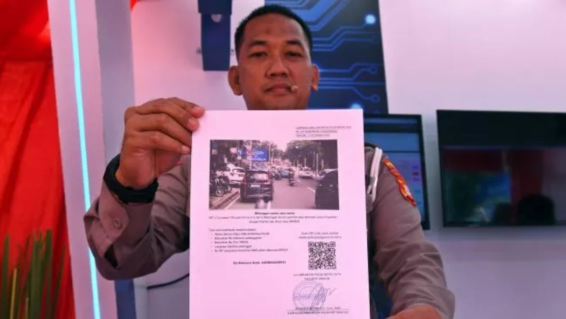 Petugas menunjukkan contoh surat tilang dari sistem tilang elektronik (ETLE) Mobile yang diluncurkan di Mapolda Metro Jaya, Jakarta, Selasa (13/12/2022). [ANTARA FOTO/Aditya Pradana Putra].