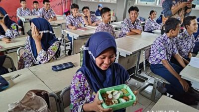 Seorang siswi menunjukan menu makan saat simulasi penerapan program makan siang gratis di SMP Negeri 2 Curug, Kabupaten Tangerang, Banten, Kamis (29/2/2024). ANTARA/Azmi Samsul Maarif.
