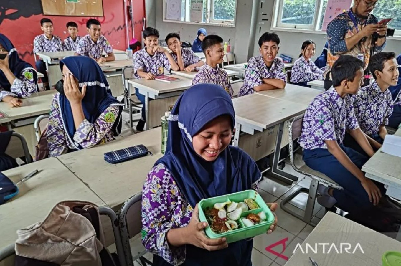 Seorang siswi menunjukan menu makan saat simulasi penerapan program makan siang gratis di SMP Negeri 2 Curug, Kabupaten Tangerang, Banten, Kamis (29/2/2024). ANTARA/Azmi Samsul Maarif.