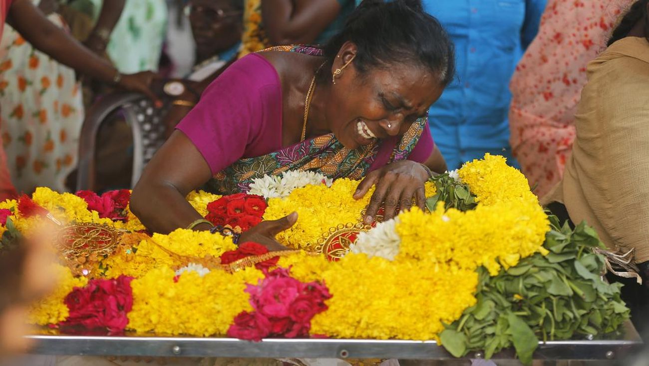 Seorang wanita menangisi jenazah keluarganya yang menjadi korban miras oplosan di India Selatan (AP Photo/R. Parthibhan)