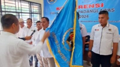 Ketua PWI Sumut, H Farianda Putra Sinik SE menyerahkan bendera PWI kepada ketua terpilih.(Ist)