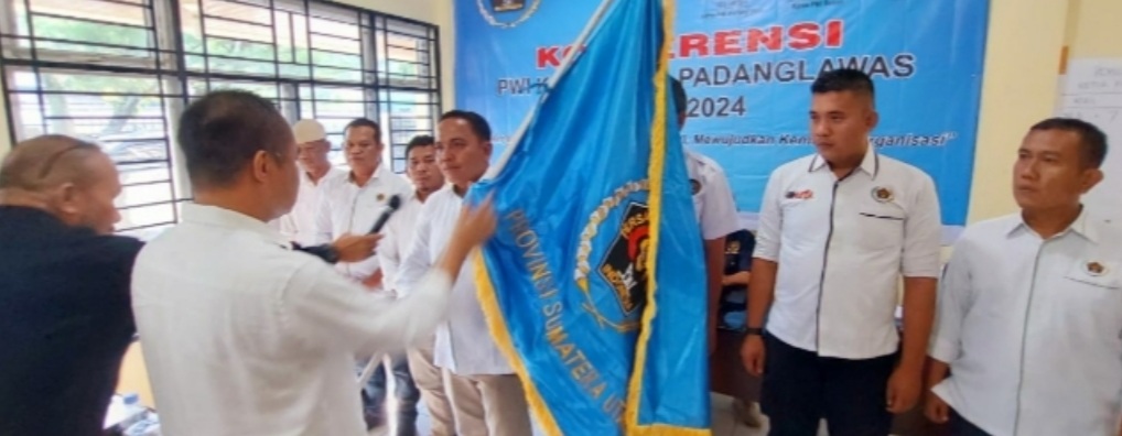 Ketua PWI Sumut, H Farianda Putra Sinik SE menyerahkan bendera PWI kepada ketua terpilih.(Ist)