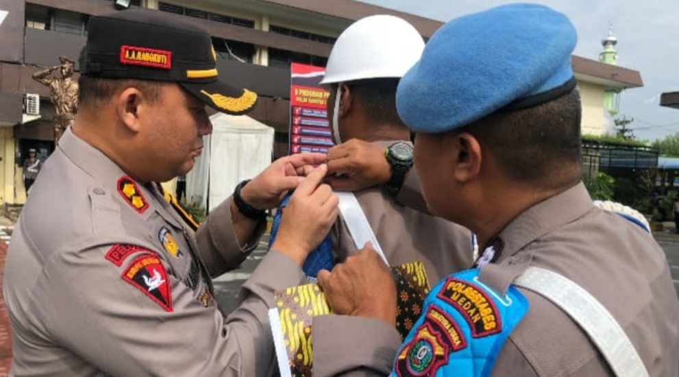 Waka Polrestabes Medan menyematkan pita Ops Mantap Praja Toba kepada personil.(ist)