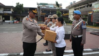 Kapolrestabes Medan Kombes Pol Gidion Arif Setyawan secara simbolis menyerahkan bingkisan Natal kepada personel.(ist)