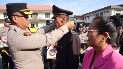 Kapolrestabes Medan Kombes Pol Gidion Arif Setyawan menyematkan tanda wisuda purna bhakti.(ist)