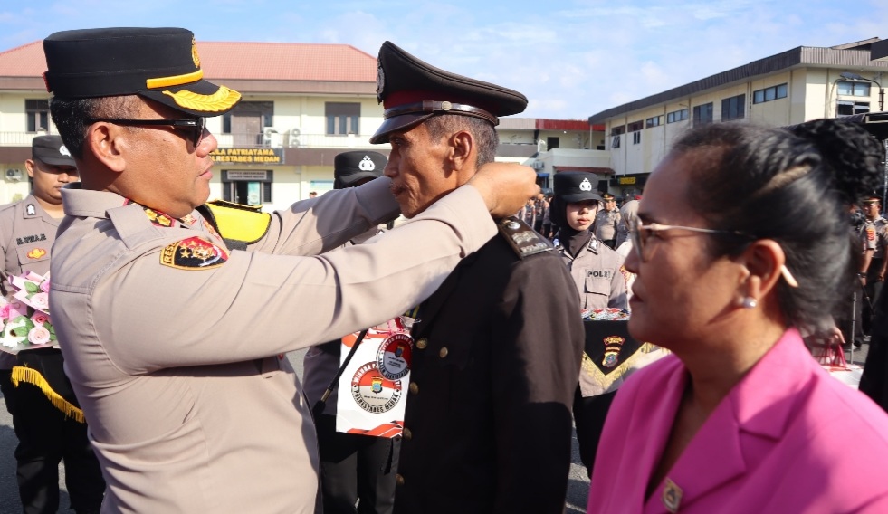 Kapolrestabes Medan Kombes Pol Gidion Arif Setyawan menyematkan tanda wisuda purna bhakti.(ist)