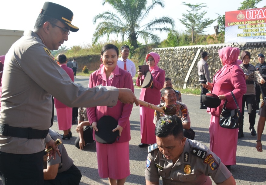 Kapolres Labusel, AKBP Arfin Fachreza menyirami air kembang ke personel yang naik pangkat.(ist)