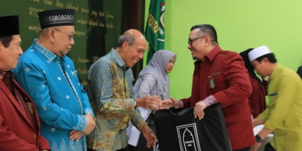 Ketua Umum Pengurus Yayasan UISU Ir Indra Gunawan, MP menyerahkan bingkisan kepada mantan rektor dan wakil rektor.(ist)