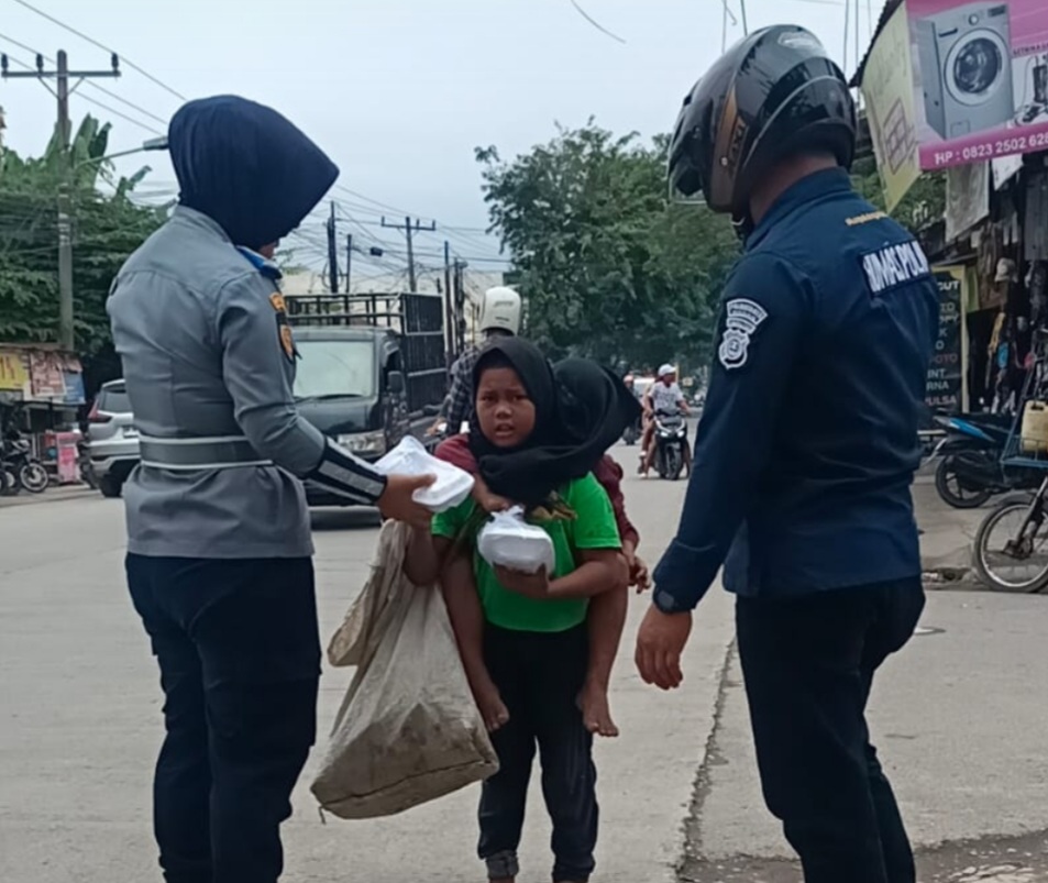 Personel Humas Polrestabes Medan dan Dishub Medan bagikan paket makanan.(ist)