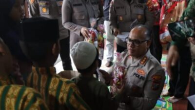 Kapolrestabes Medan Kombes Pol Gidion Arif Setyawan berbaur dengan anak-anak panti asuhan sambil menyalaminya. (ist)