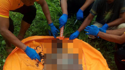 Petugas INAFIS Polresta Deliserdang saat melakukan pemeriksaan terhadap jenazah diduga wanita yang ditemukan di parit depan Sport Center Batangkuis, Sabtu (17/5/2025).