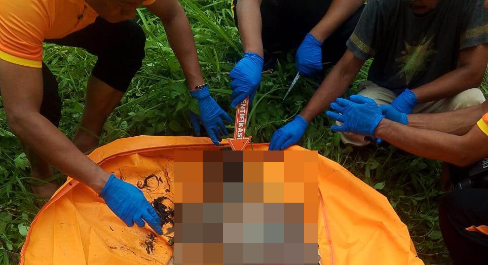 Petugas INAFIS Polresta Deliserdang saat melakukan pemeriksaan terhadap jenazah diduga wanita yang ditemukan di parit depan Sport Center Batangkuis, Sabtu (17/5/2025).