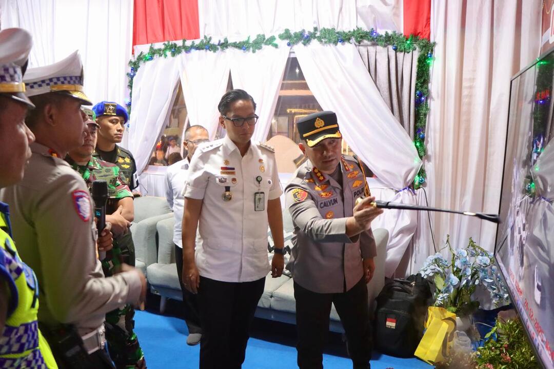 Kombes Pol Jean Calvijn Simanjuntak menjelaskan kepada Rico Waas peta pengamanan Nataru di Medan.(humas)